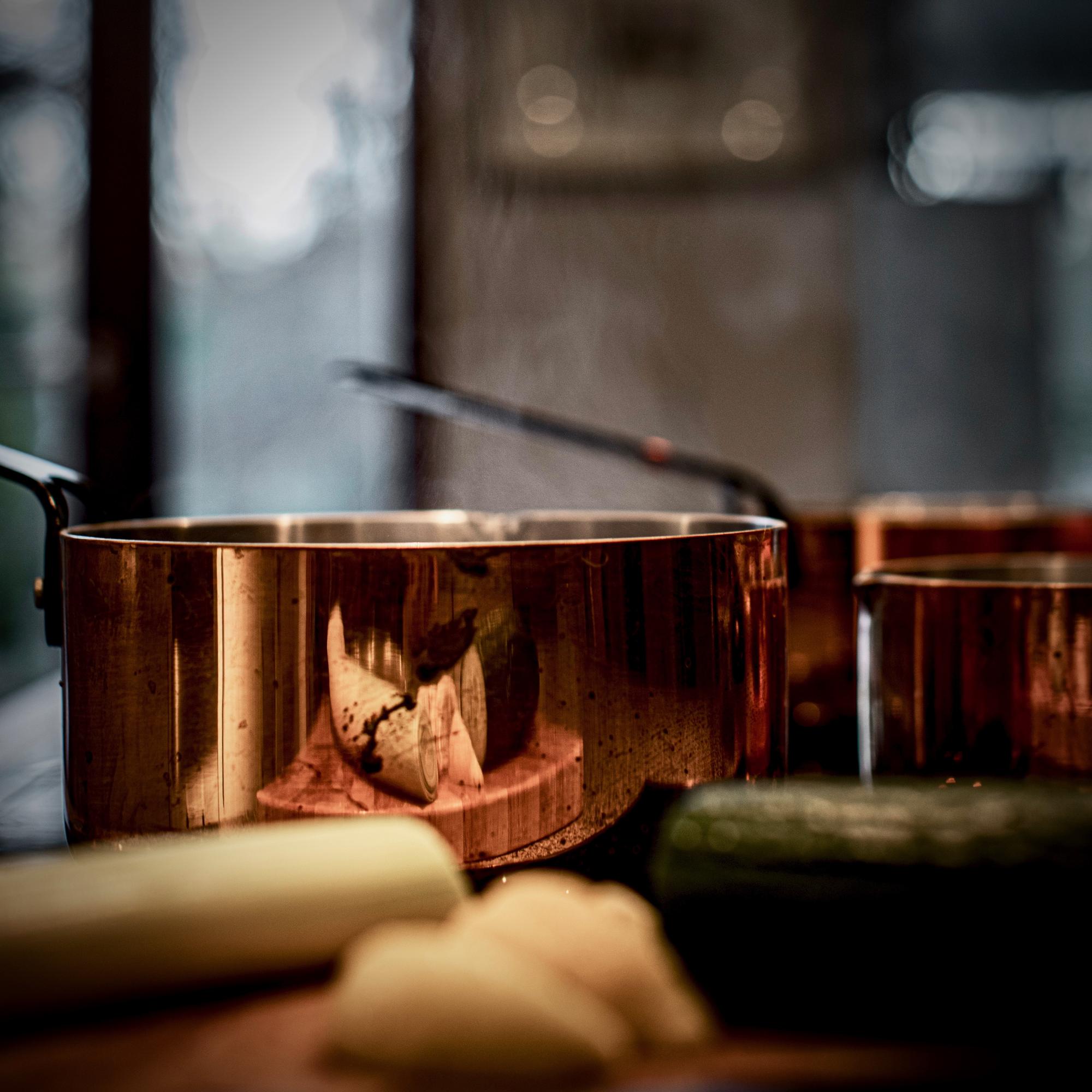 Small professional kitchen workspace with copper pans